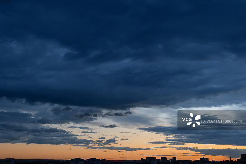 日落时分云天下远处的建筑物剪影图片素材