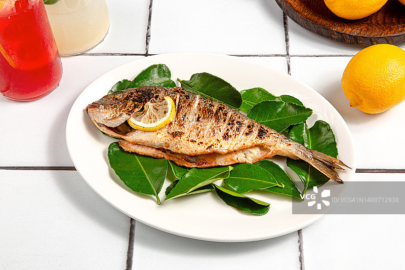 烤鱼肉配柠檬和叶子图片素材