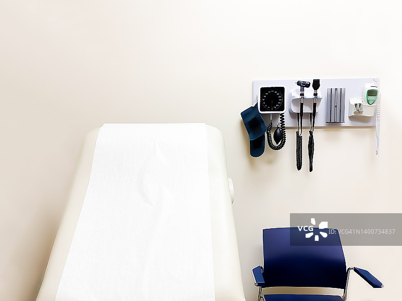 医疗保健：墙上的医疗诊断设备和标准病人检查椅图片素材