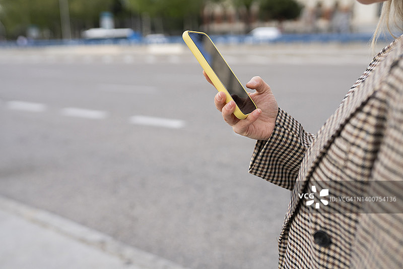 女人在城市里手持智能手机图片素材
