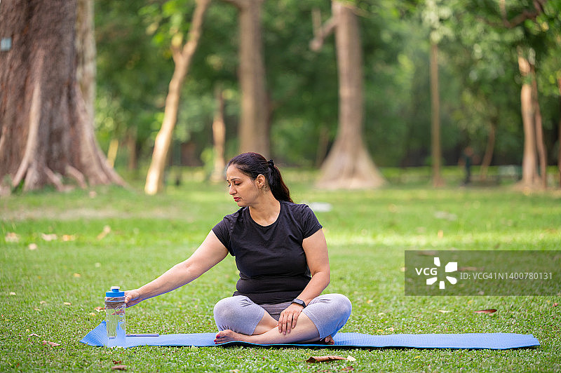 中年妇女在瑜伽后喝塑料瓶里的水图片素材