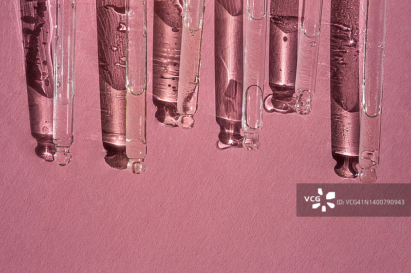 一排化妆品滴管，粉色背景图片素材