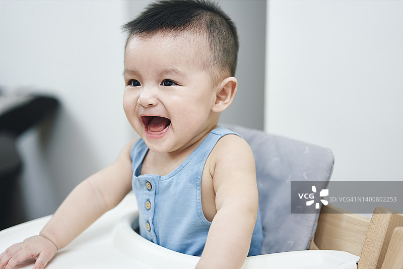 坐在椅子上兴奋的亚洲男婴图片素材