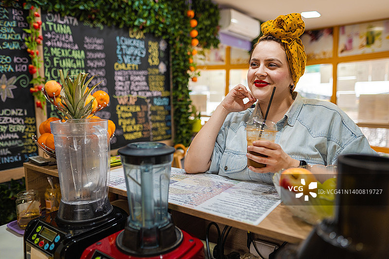 年轻女人在健康酒吧喝巧克力奶昔图片素材