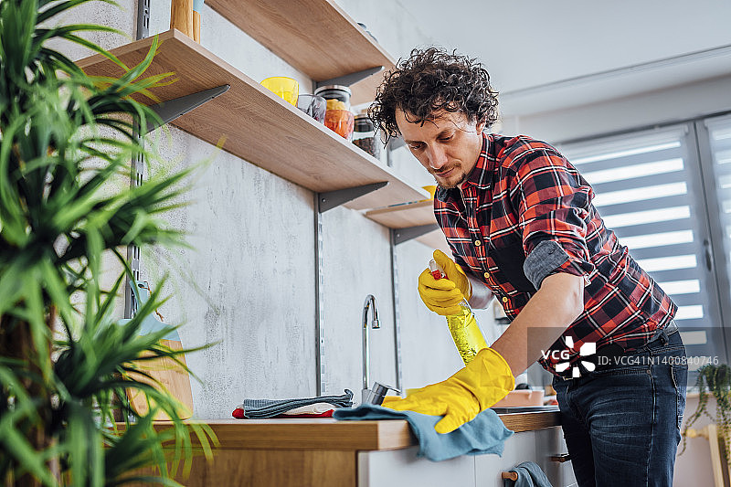 男子喷洒清洁厨房台面图片素材