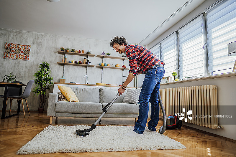 男人用吸尘器打扫房子图片素材