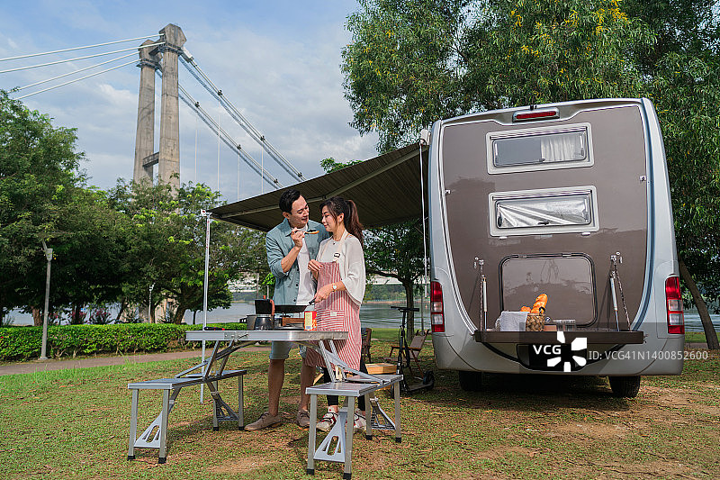 年轻夫妇在露营车旅行中烹饪美食图片素材