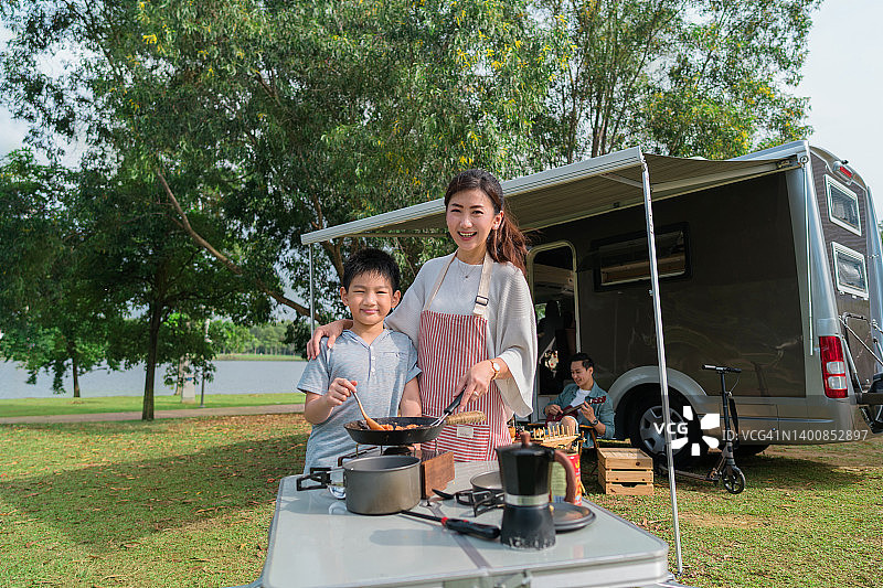 母亲和儿子在房车露营时烹饪图片素材