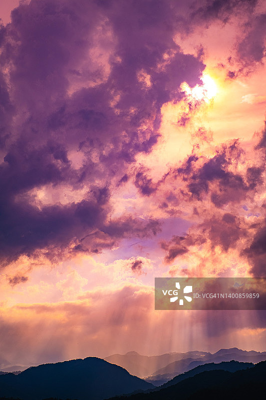 阳光穿透群山云层的壮丽景色图片素材