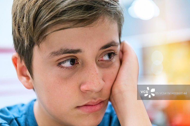 悲伤、沉思、忧虑的青少年男孩望向远方图片素材