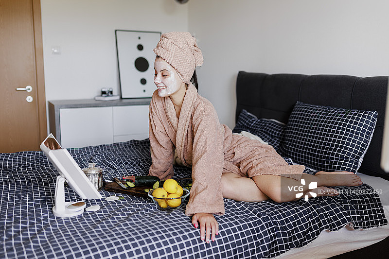 女性在床上进行皮肤护理图片素材