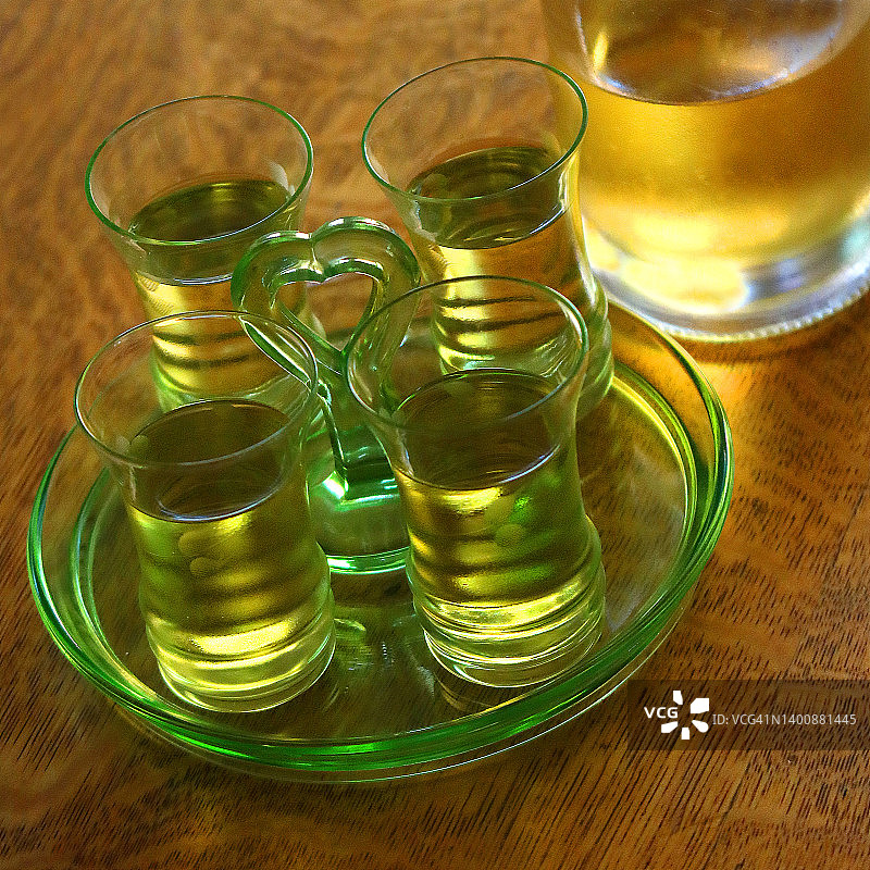 玻璃托盘，装有柠檬酒的4个小酒杯和1个瓶子图片素材