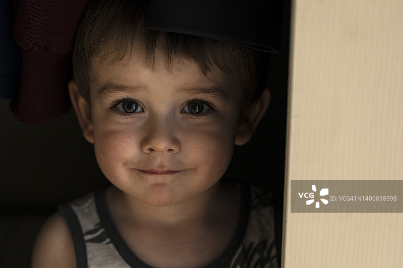 调皮的幼儿从门后探出头图片素材