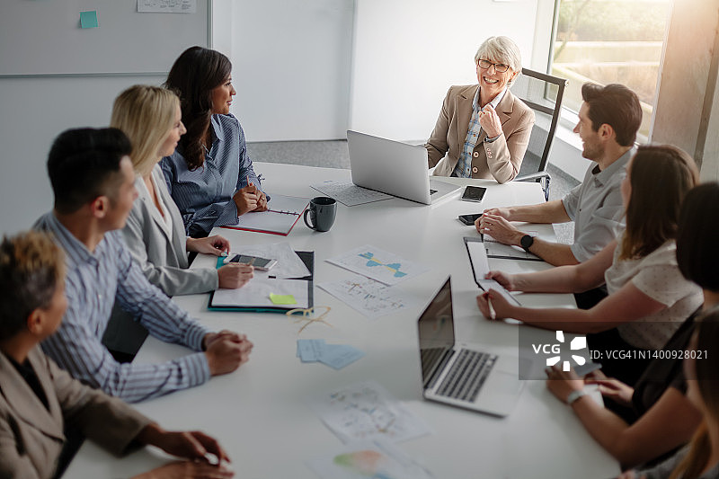 年长的女商人与多元化同事在现代创意办公室内开会讨论业务图片素材