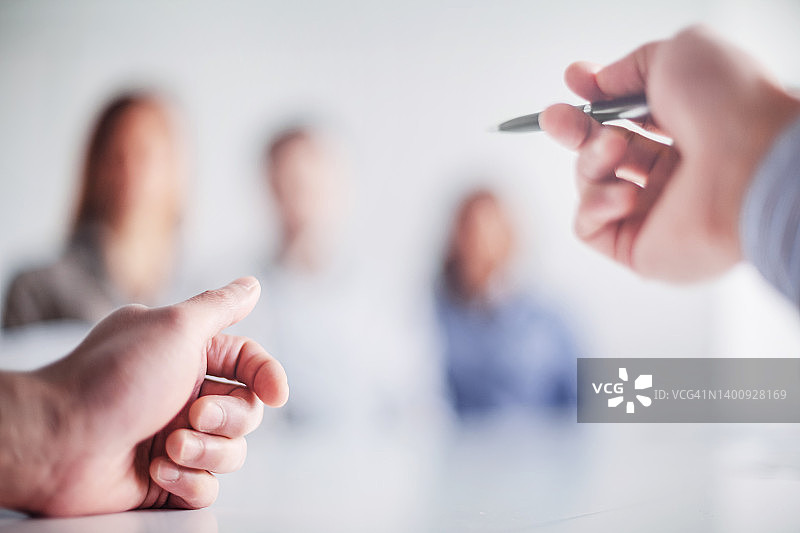 商务会议期间，发言人在办公室的桌旁用笔势示意的手部个人视角图片素材