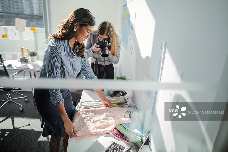 亚裔中年女商人检查服装面料样品质量图片素材