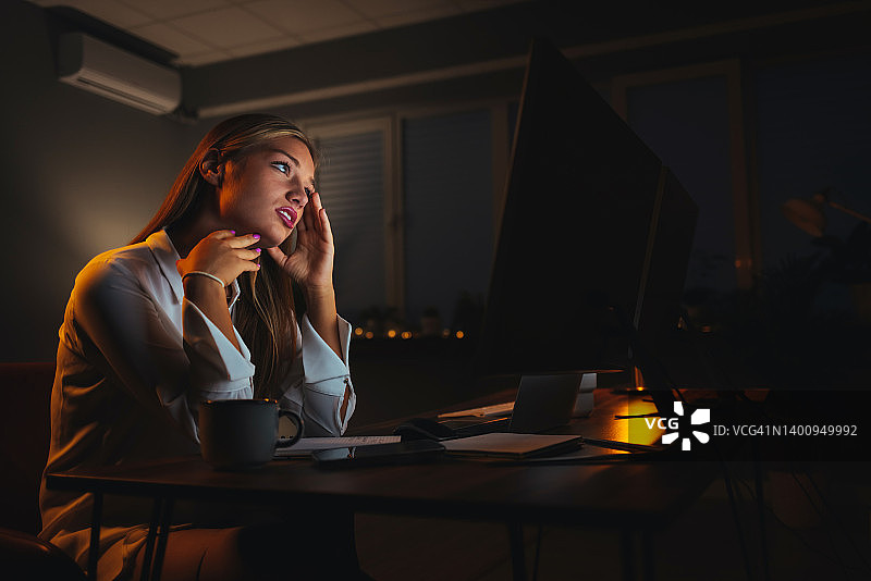 夜晚使用多种设备工作的企业家图片素材
