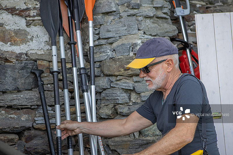 年长的男人在皮划艇体验前选择船桨图片素材