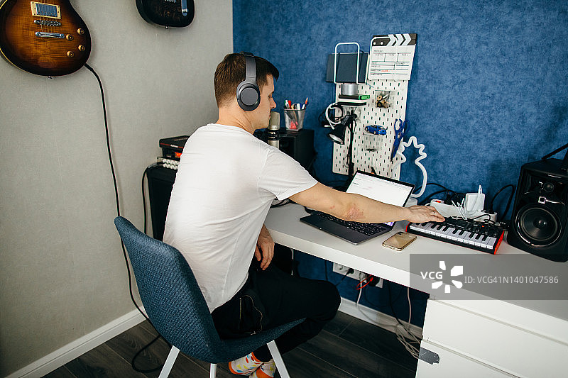 年轻男人用电子效果器和笔记本电脑制作音乐图片素材