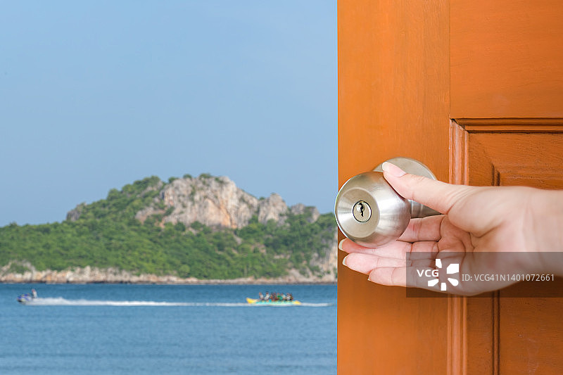 手打开通往蓝色大海的木门图片素材