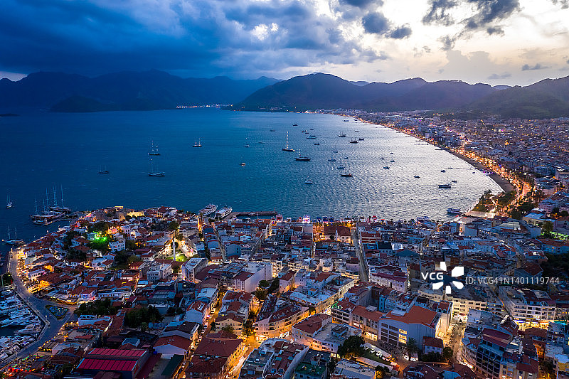 马尔马里斯海港的游艇和帆船与夜间照明鸟瞰：土耳其城市美丽的日落景色图片素材