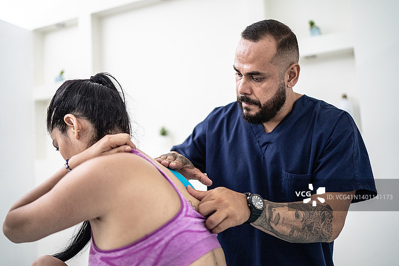 理疗师为中年妇女贴肌内效贴图片素材