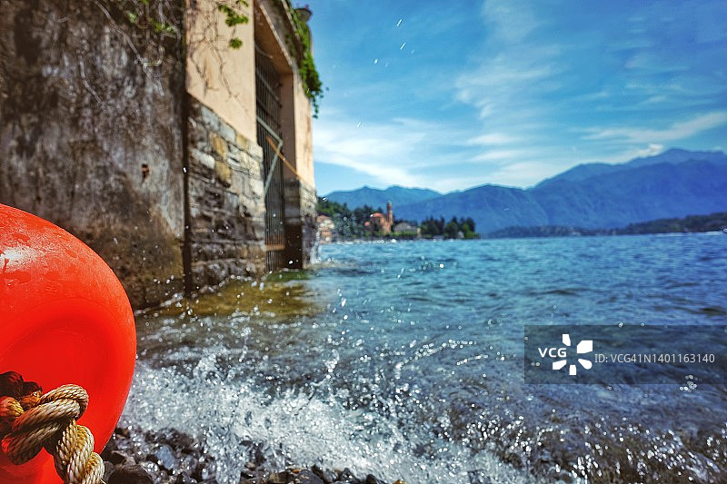 从下方看到的湖岸，石头间有水花和浮标图片素材