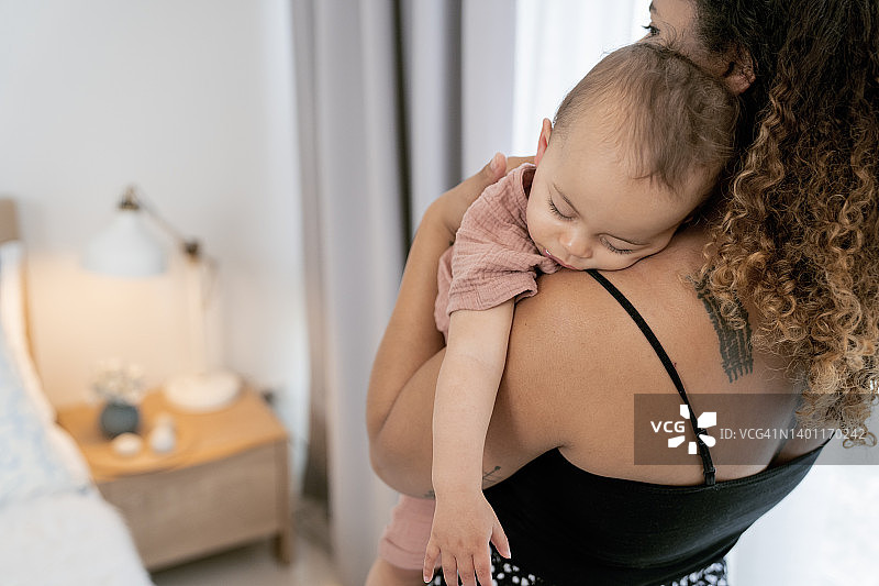 新手妈妈在家中安慰烦躁的新生儿子图片素材