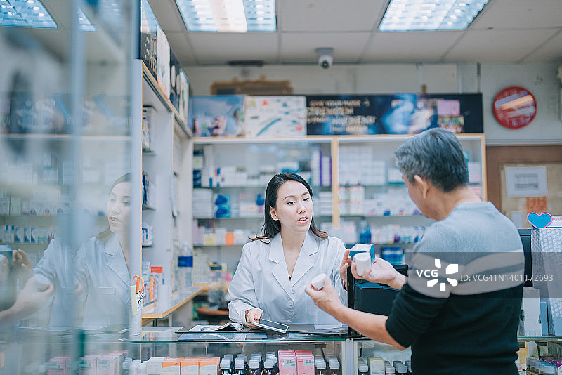 老年男人在药店咨询女药剂师医疗用品图片素材