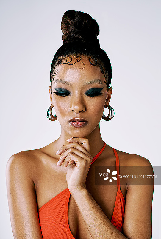 美丽的非洲女人化着时尚妆容，灰色背景，穿着红色泳衣，烟熏黑色眼影，美丽与魅力图片素材