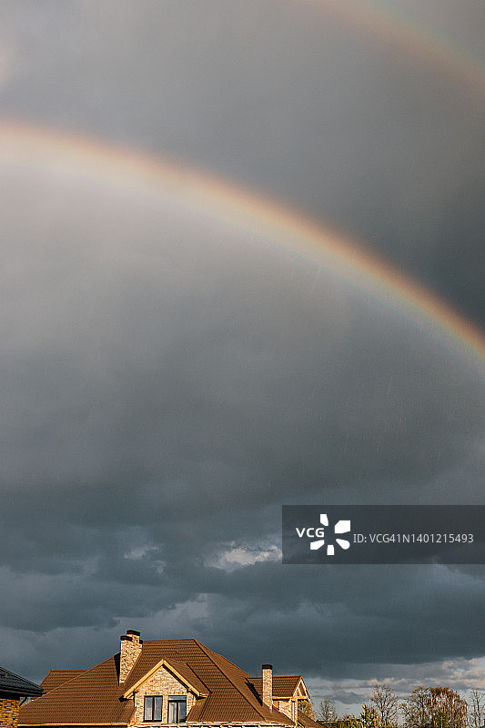 郊区暴雨天空中两道七彩彩虹图片素材