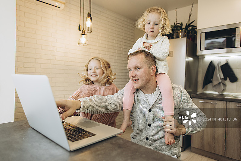 父亲在家工作，女儿坐在肩膀上图片素材