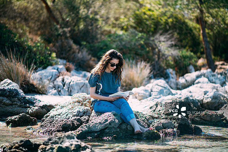 年轻女人在海滩看书放松图片素材