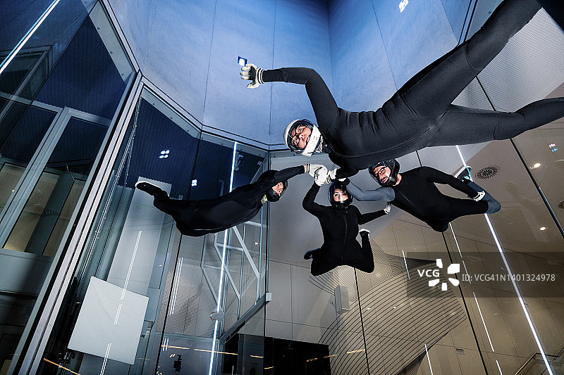 运动员手牵手在风洞中飞行图片素材