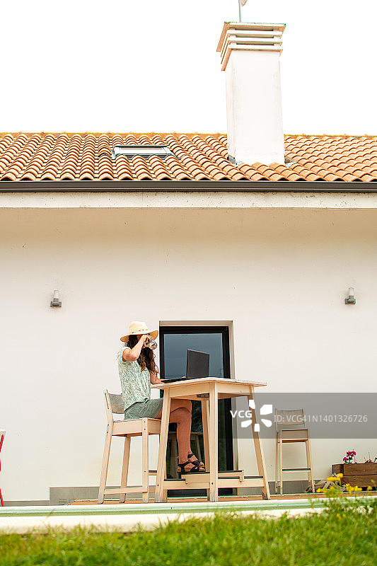 在花园露台上远程办公的女人图片素材
