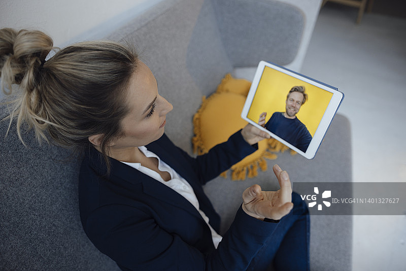 女商人通过平板电脑在办公室进行视频通话讨论图片素材