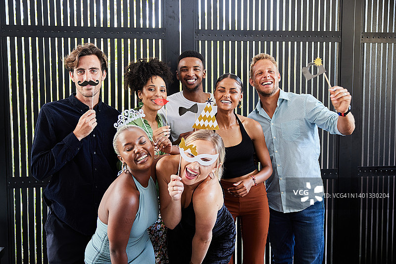 一群朋友在派对上使用拍照亭配件合影图片素材