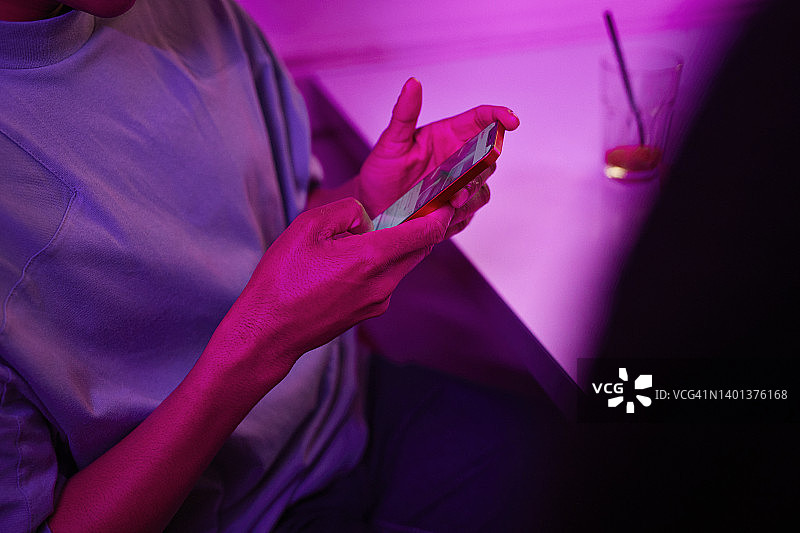 年轻男人在桌旁使用智能手机图片素材