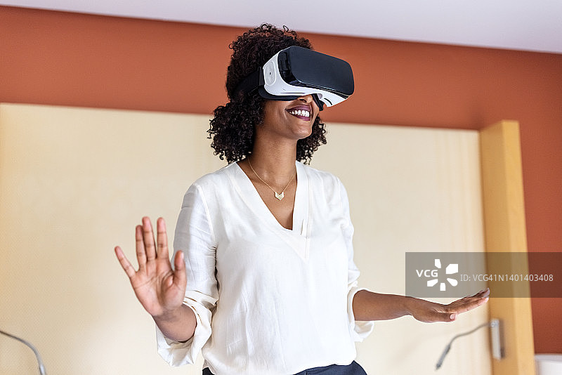 女人在酒店房间里戴着VR眼镜体验虚拟现实图片素材