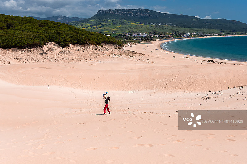 母亲在细沙滩上举起她的宝宝图片素材