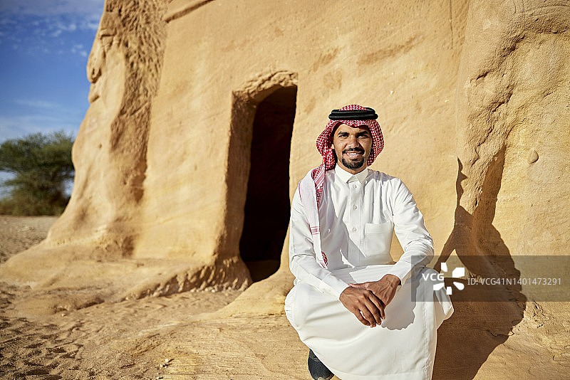 参观Hegra的快乐年轻沙特男子户外肖像图片素材