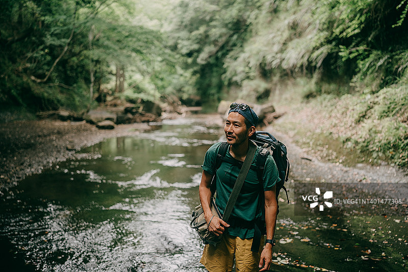 男子在日本千叶县的森林河流中徒步旅行图片素材