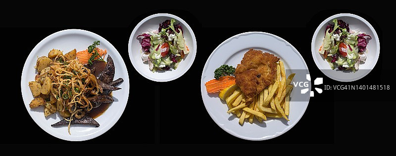 烤猪肝配炸洋葱和炸土豆，维也纳炸肉排配炸薯条，均配混合沙拉，黑色背景，德国巴伐利亚图片素材