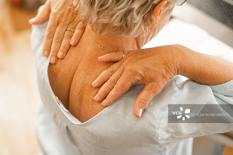 年长的女人按摩颈部疼痛部位图片素材