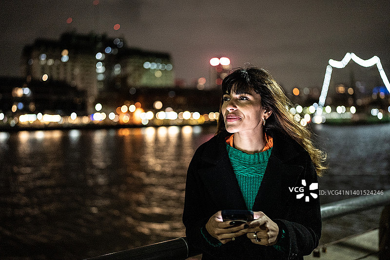 沉思的年轻女子在户外使用手机图片素材