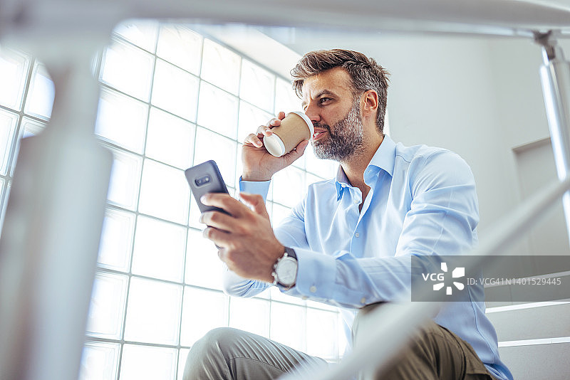 年轻的商务人士正在使用手机浏览图片素材