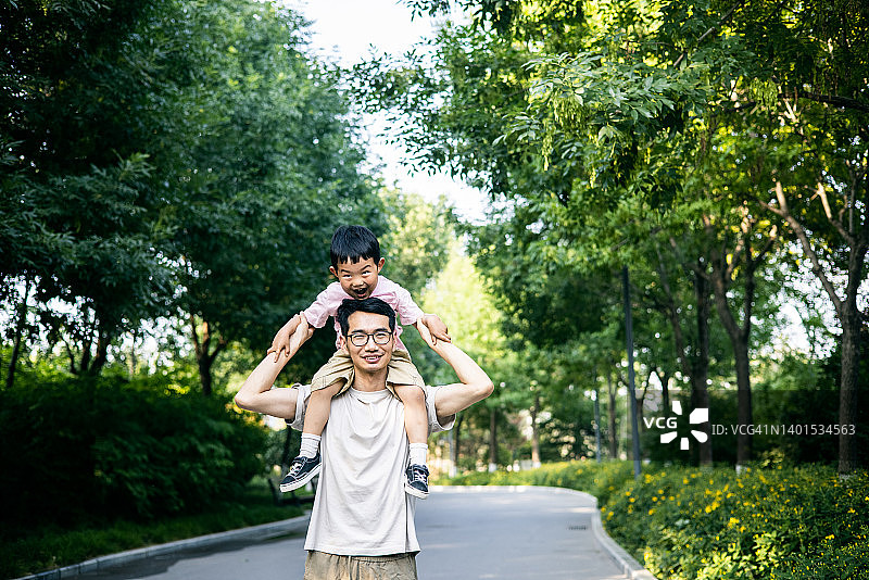 父亲在公园背着儿子图片素材