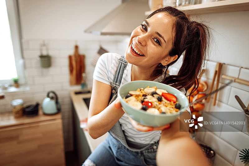 年轻漂亮的女人手捧一碗麦片摆姿势图片素材