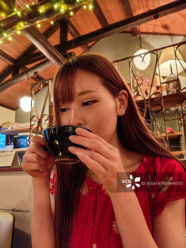 年轻女人在咖啡馆放松地喝咖啡图片素材