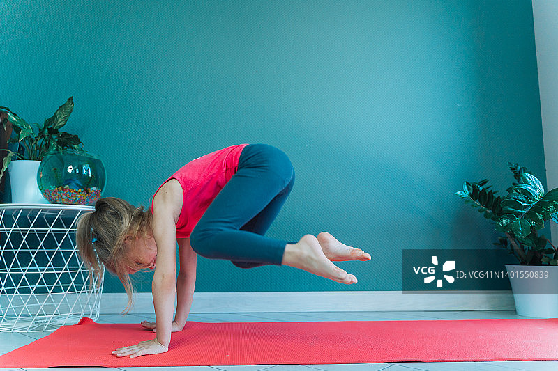 试图做鹤禅式瑜伽的小女孩图片素材